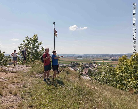 Wanderer auf dem Wallersteiner Felsen, die den Blick ins Ries genießen.