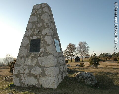 Der Gedenkstein der Schlacht am Albuch mit dahinter liegender Heidelandschaft.