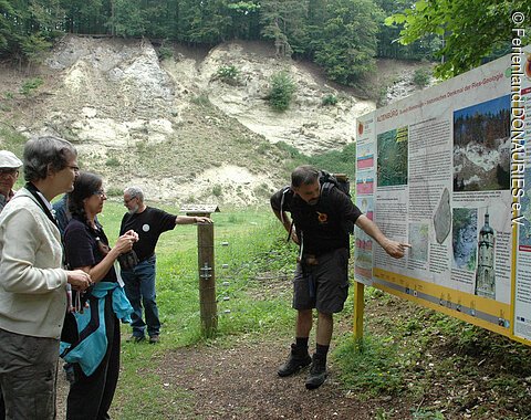 Ein Geoparkführer an der Infotafel bei der Alten Bürg mit Teilnehmern einer Geopark-Führung
