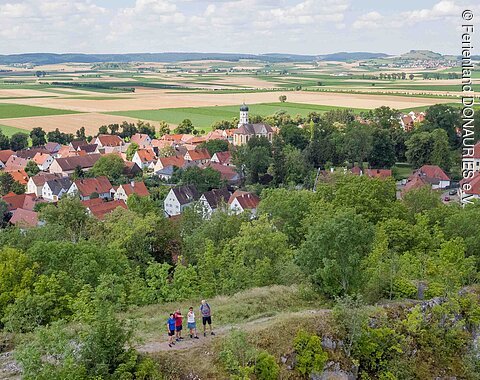 Wanderer auf dem Wallersteiner Felsen. Im Hintergrund sieht man Wallerstein.