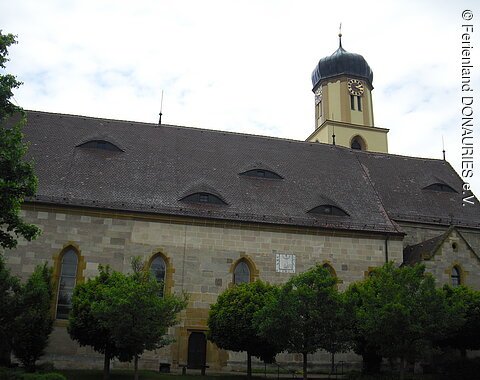 Außenansicht Pfarrkirche St. Peter und Paul, Unterschneidheim Blick auf die teilweise hinter Bäumen verborgende Pfarrkirche St. Peter und Paul