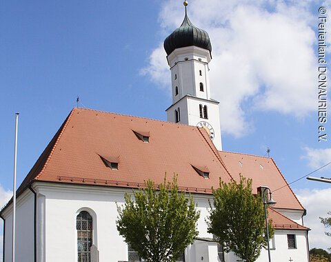 Blick auf die Pfarrkirche St. Nikolaus mit davor stehendem Brunnen