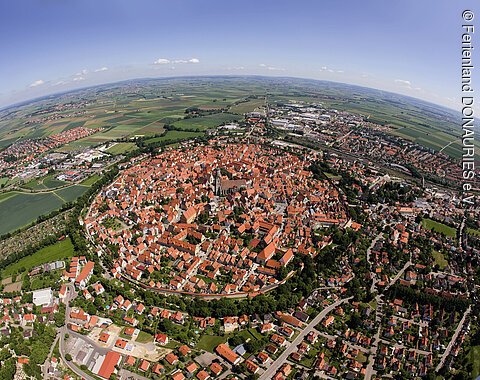 Luftaufnahme von Nördlingen. Gut zu erkennen ist die kreisrunde Stadtmauer und die St. Georgskirche mit dem Kirchturm in der Mitte der Stadt.