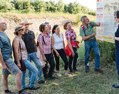 Eine Führerin mit Besuchern an einer Infotafel im Geotop Glaubenberg
