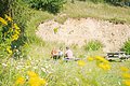Drei Wanderer bei einer Rast an Holztischen im Geotop Klosterberg