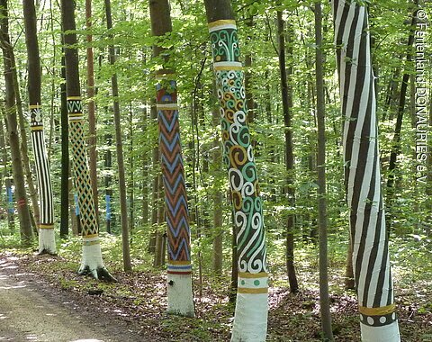 Mit Farbe verzierte Baumstämme im Kunstwald