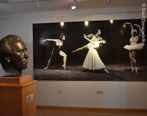 Eine Büste von Werner Egk und Ballett-Bilder an der Wand