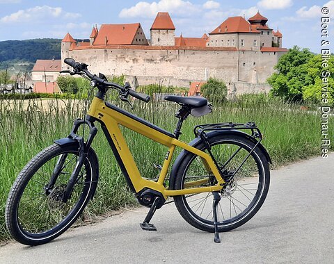 E-Bike auf einem Radweg bei Harburg. Im Hintergrund ist das Schloss Harburg zu sehen.