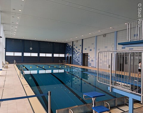 Blick auf das Schwimmbecken mit Sprungturm im Hallenbad in Rain Blick auf das leere Schwimmbecken mit zwei unterschiedlich hohen Schwimmtürmen im Hallenbad in Rain.