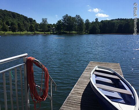 Ein Ruderboot auf dem Steg am Waldsee