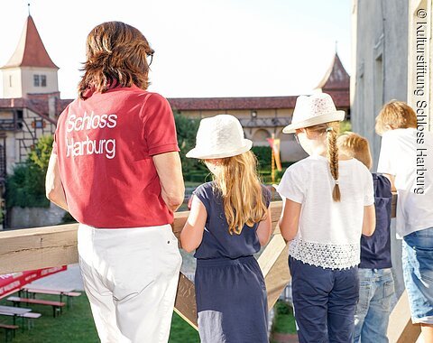 Eine Führerin blickt mit Kindern in den Burghof von Schloss Harburg