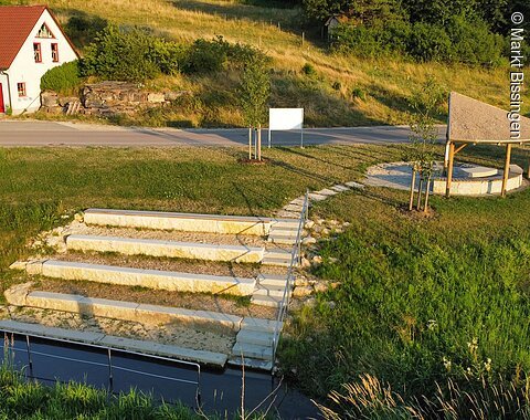 Blick auf die Kneippanlage mit überdachter Sitzgelegenheit und Barfußpfad