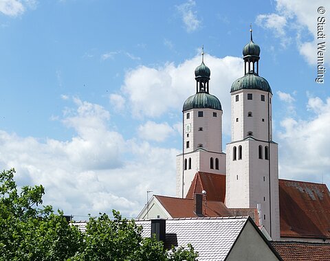 Blick auf die Türme der Stadtpfarrkirche mit weiß blauem Himmel