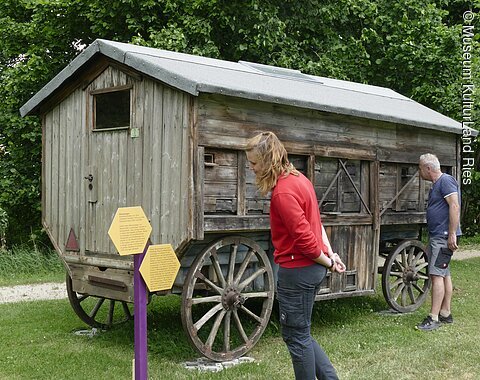 Besucher im Bienengarten mit Infotafeln.