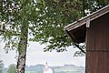 Eine Frau und ein Kind liegen auf einer Liege unter einem Baum und blicken in die Ferne.