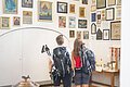 Ein pilgerndes Paar blickt in der Wallfahrtsbasilika Maria Brünnlein auf verschiedene angebrachte Votivtafeln.