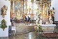 Zwei Pilger stehen im Altarraum in der Wallfahrtsbasilika Maria Brünnlein und blicken zur Stuckdecke.