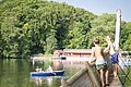 Zwei Kinder stehen auf dem Piratenschiff und beobachten ein Ruderboot, dass auf dem Waldsee in Wemding fährt.