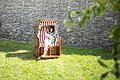 Eine Frau sitzt im Strandkorb im Stadtgraben und liest ein Buch.