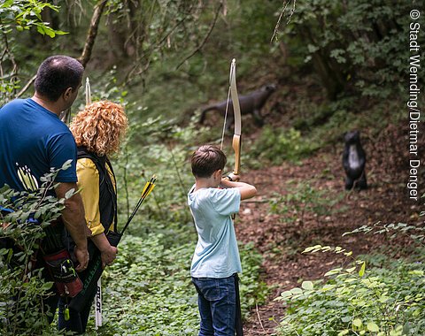 Eine Familie ist am 3D-Bogenschieß-Parcour unterwegs.