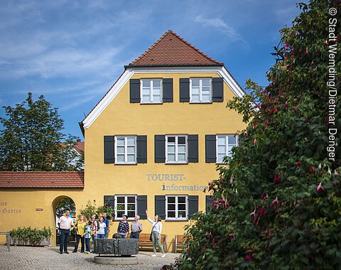 Die Stadtführerin ist mit einer Gruppe am Mangoldbrunnen vor der Tourist-Information.