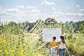 Eine Familie betrachtet eine Informationstafel im botanischen Obstlehrgarten.