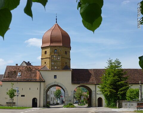 Ein alter Turm einer Stadtmauer mit zwei Durchgängen.
