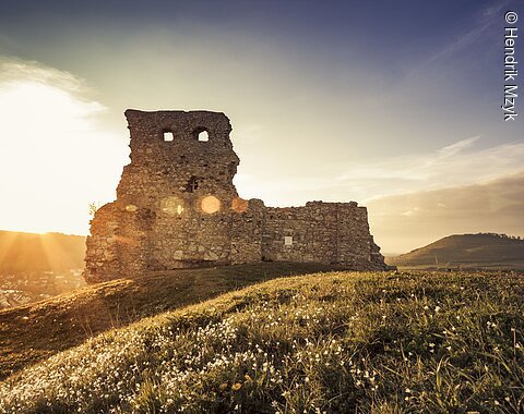 Reste von einer alten Burgmauer im Sonnenuntergang.