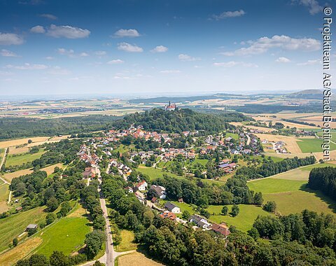 Luftaufnahme von Baldern Aus der Luft sieht man grüne Wiesen und einem Ort. Dort steht ein Schloss auf einem Hügel