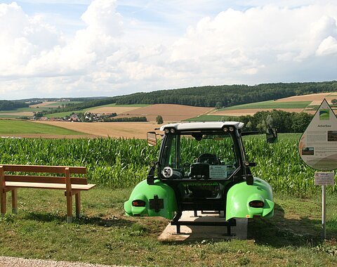 Halber Traktor auf dem Feld um die Arbeit eines Landwirts zu veranschaulichen
