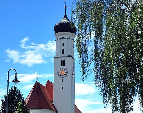 Pfarrkirche der Gemeinde Oberndorf; ein schlanker weißer Turm mit einer hohen schlanken Apsis