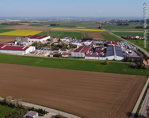 An einer Straße liegendes Gewerbegebiet umgeben von Feldern