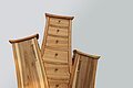 Holzkommode mit geschwungenem Design und mehreren Schubladen, steht auf Steinboden.
