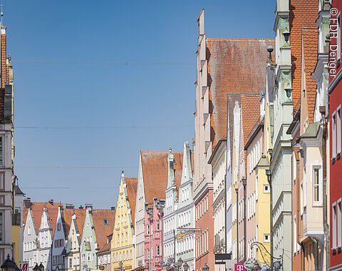 Reichsstraße Donauwörth Straße mit bunten, historischen Gebäuden und Satteldächern unter blauem Himmel.
