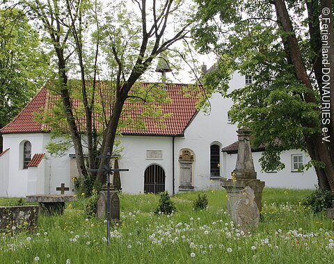 Der Blick durch Bäume hindurch, auf die St. Anna Kapelle