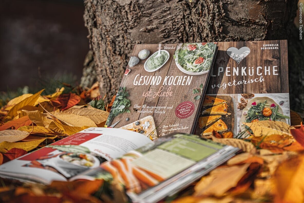 Verschiedene Kochbücher der Bücherei im Herbstlaub dekoriert.