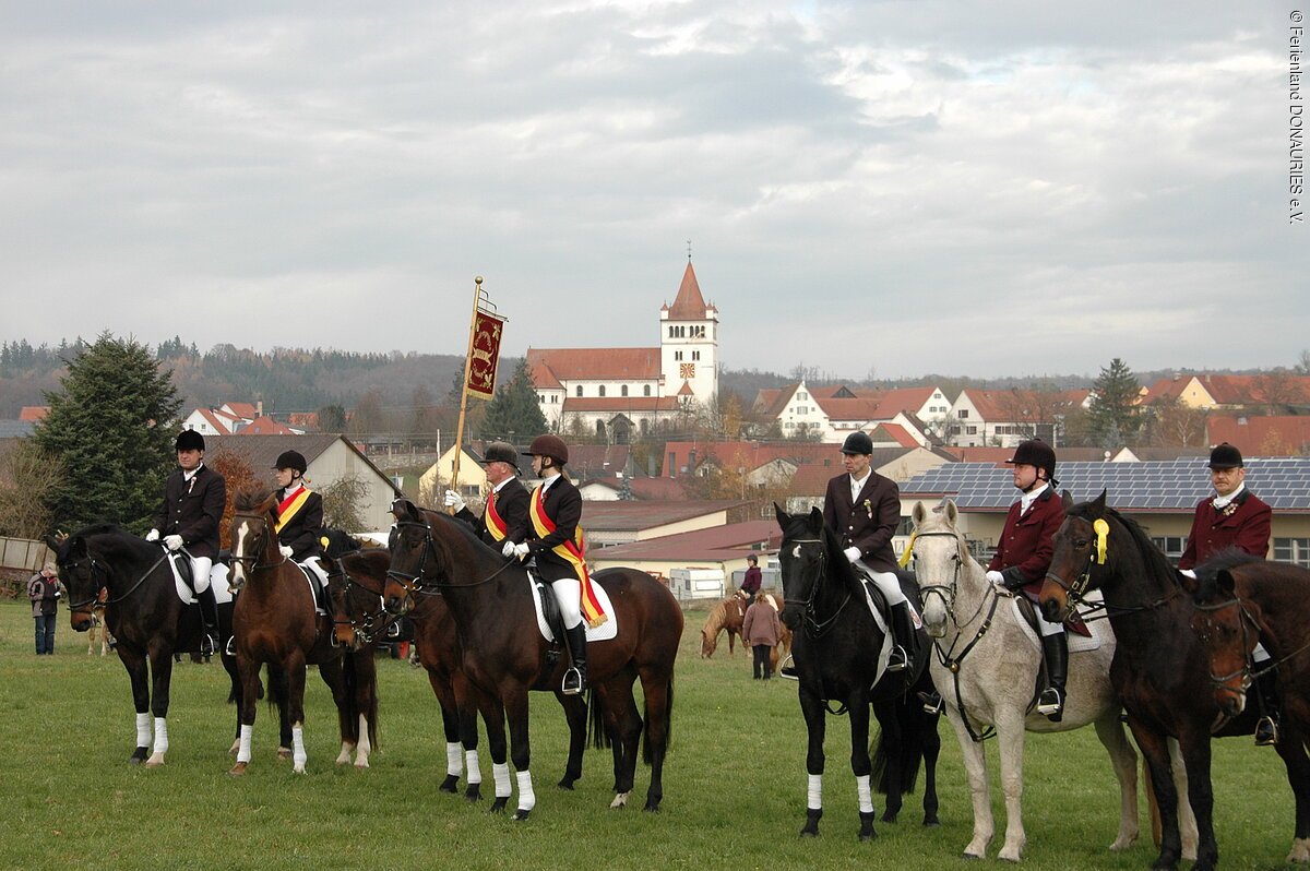 Leonhardiritt bei Fremdingen Reiter auf einer Wiese beim Leonhardiritt. Im Hintergrund sieht man den Ort und die Kirche.