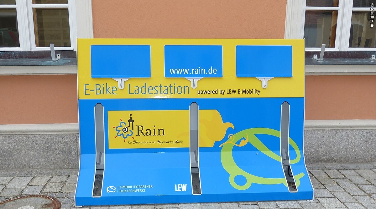 Die blau-gelbe E-Bike Ladestation in Rain am Rathaus