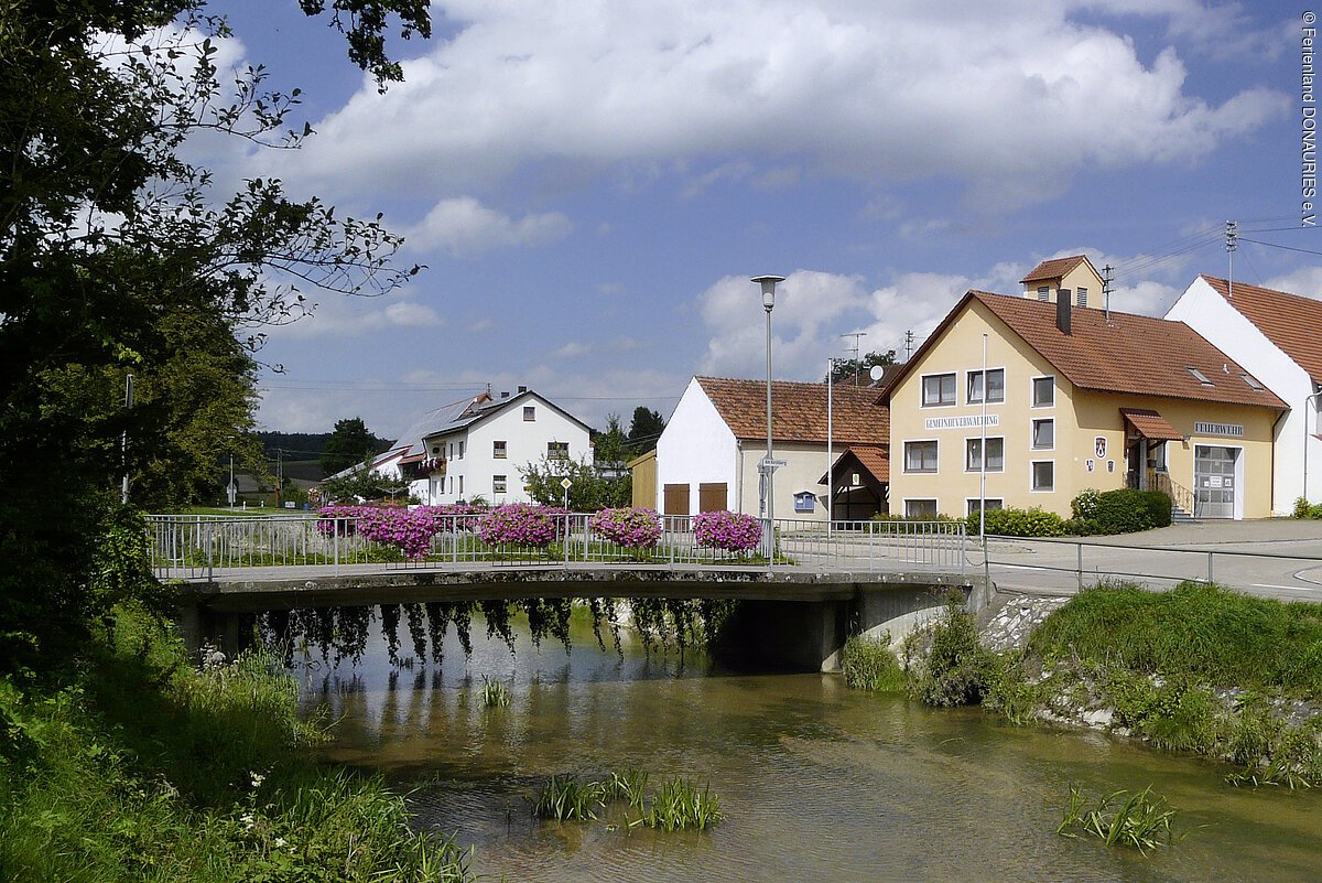 Blick auf die Usselbrücke in Daiting mit Häusern im Hintergrund.