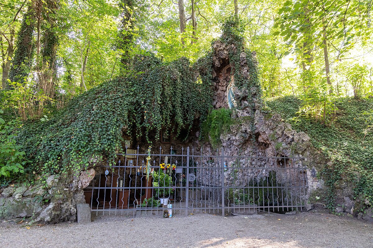 Grotte Rain Blick auf die mit Efeu bewachsene von Bäumen und Büschen dicht umschlossene Grotte.