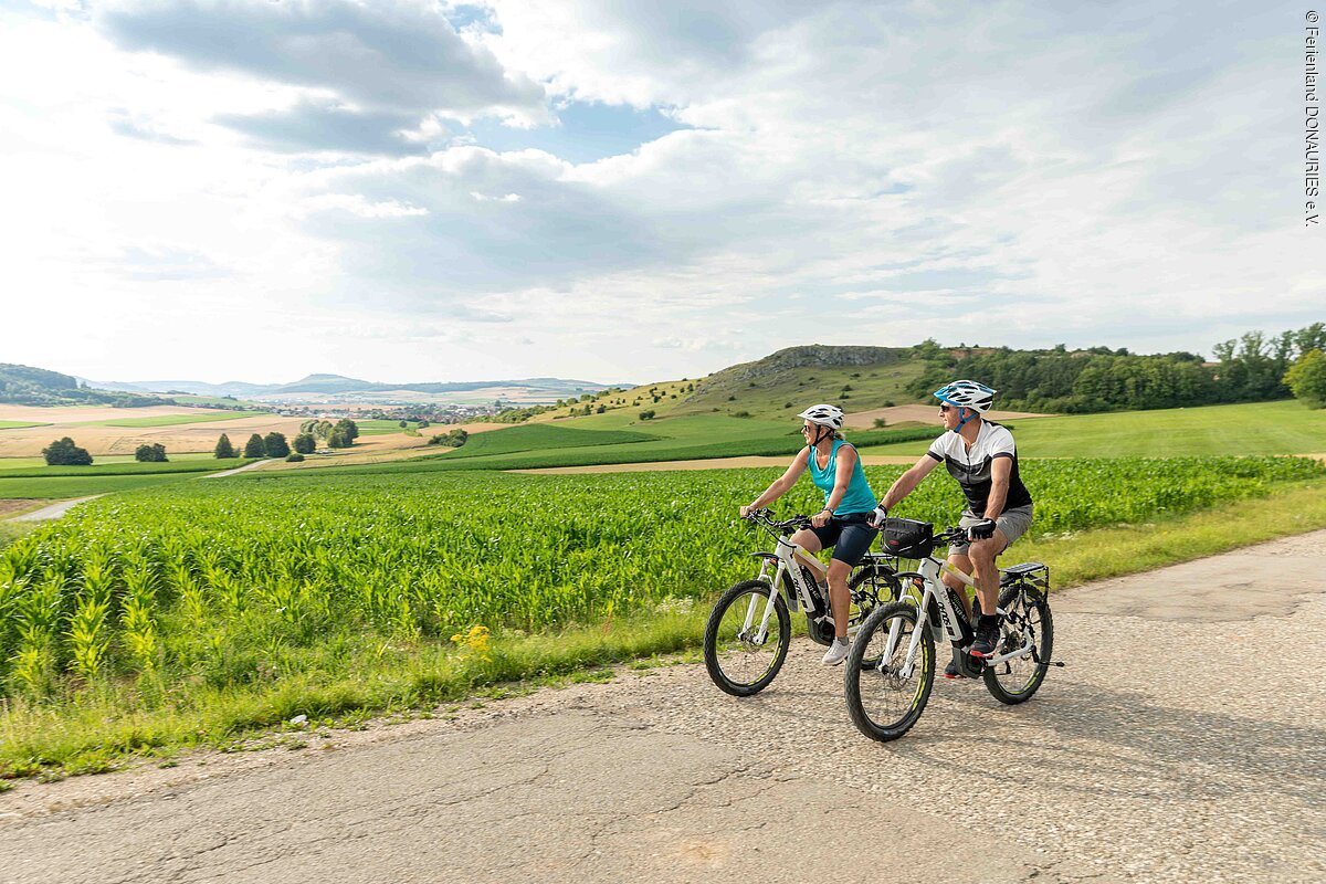 Radler unterwegs am Riegelberg. Im Hintergrund hat man einen wunderschöne Aussicht auf den Ipf.