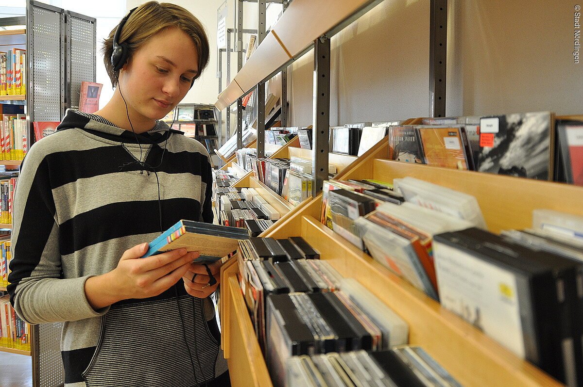 Ein Jugendlicher beim Heraussuchen einer CD.