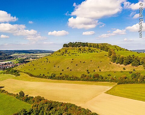 Blick auf den Ipf Blick auf den Berg namens Ipf mit Feldern und Bäumen unter blauem Himmel mit weißen Wolken.