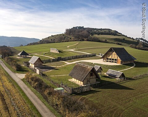 Blick aus der Luft auf das Freilichtmuseum am Ipf Luftaufnahme des historischen Freilichtmuseums am Ipf mit mehreren Fachwerkhäusern und dem Berg namens Ipf im Hintergrund.