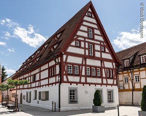 Blick auf das Seelhaus in dem sich das Ipf-Museum befindet. Fachwerkhaus mit spitzem Giebel und roten Holzbalken in einem gepflasterten Innenhof bei Tageslicht in dem sich das Ipf-Museum befindet.