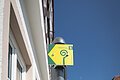 Wander- und Wallfahrerweg durch Monheim Drei leuchtend gelbe Schilder am grauen Pfosten in einer Altstadt bei blauem Himmel. Zwei Schilder zu Wanderwegen mit der Nummern 5 und 6 und ein Pilgerweg-Symbol für den Wallfahrerweg, mit dem dazugehörigen spiralförmigen Symbol.